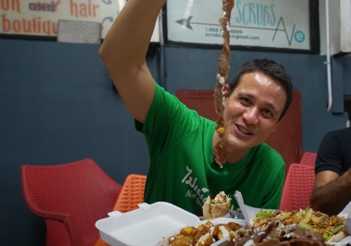 Mark Wiens eating gyro meat in Port of Spain Trinidad on a street food tour on Ariapita Avenue in POS
